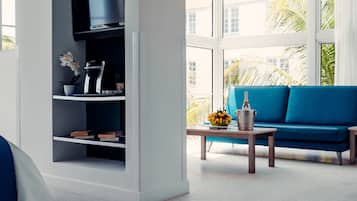 Una sala de estar moderna con un sofá azul, una cafetera y una estantería.