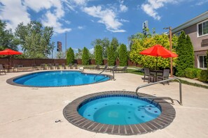 A pool area with two hot tubs and lounge chairs, surrounded by trees and a building. - Best Western Mountain View Inn (Springville)