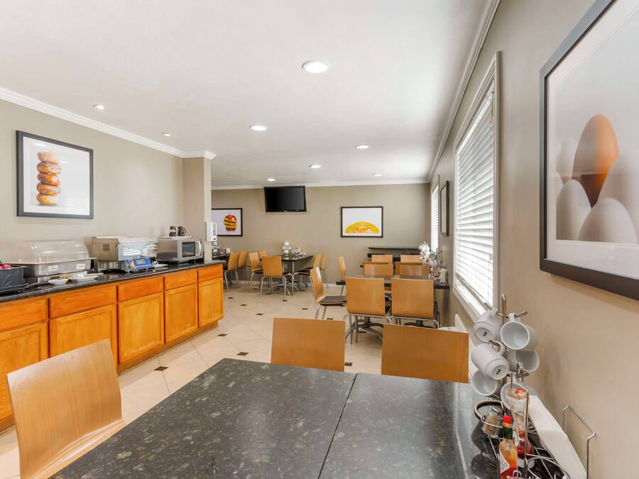 Una cocina de hotel con comedor, equipada con cafetera, microondas y sistema de buffet.