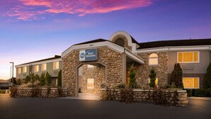 A hotel with a stone facade, a sign reading "Best Western," and a parking lot.