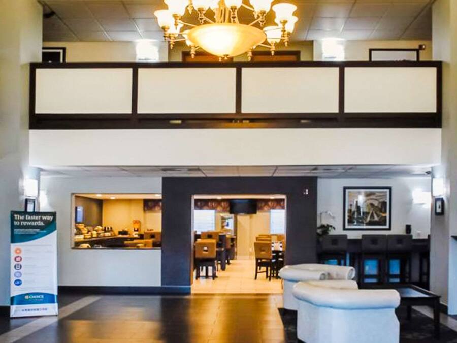 A hotel lobby with a reception desk, seating area, and a fireplace.