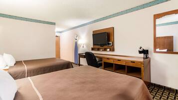 A hotel room with two beds, a desk, a chair, a television, and a coffee maker.