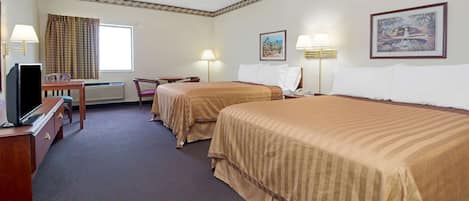 A hotel room with two beds, a desk with a television, a chair, and a window with curtains.