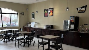 A restaurant with tables and chairs, a coffee machine, and a refrigerator. - Travelodge by Wyndham St. Louis (St. Louis)