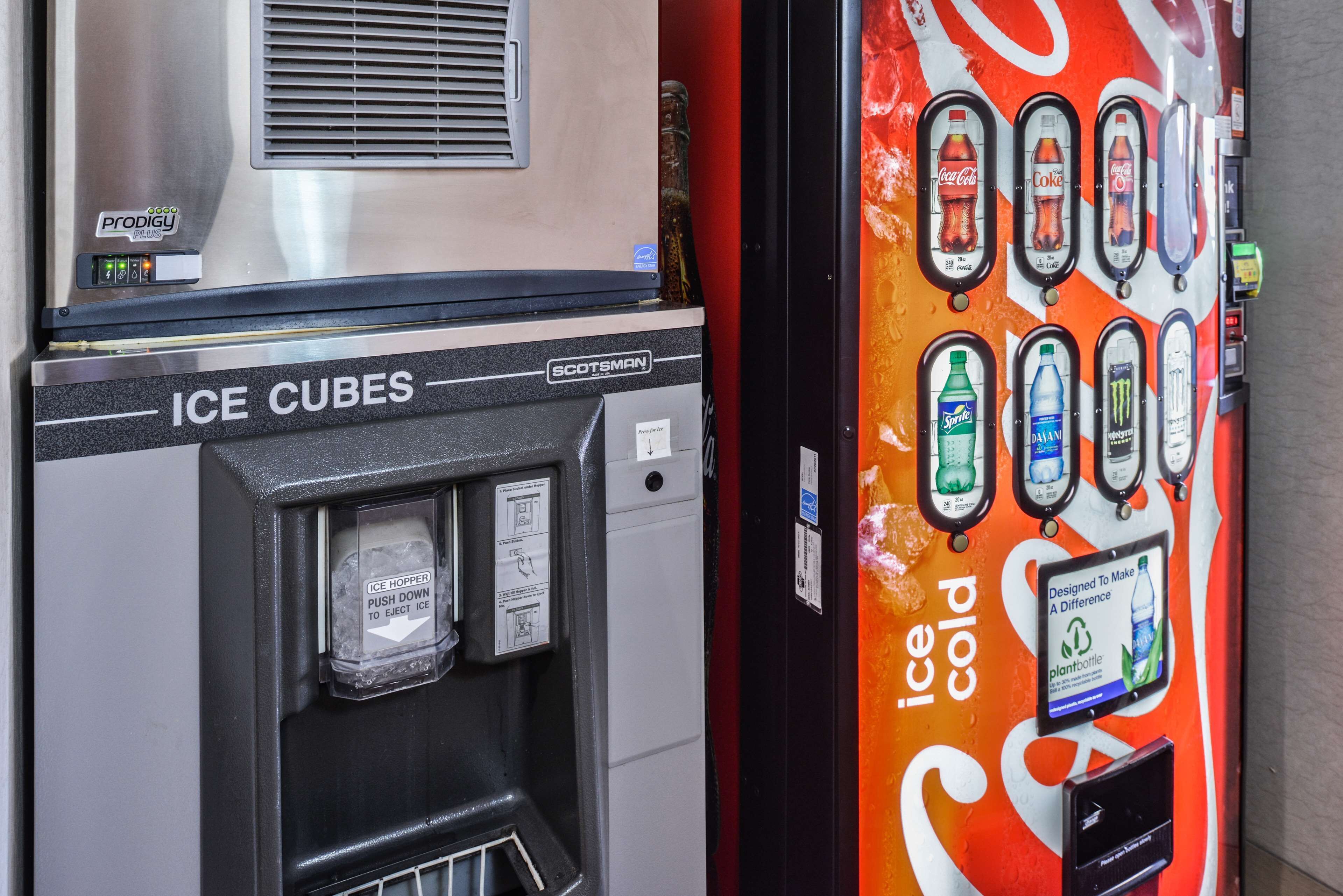 A vending machine with an ice dispenser and a Coca-Cola themed drink dispenser.