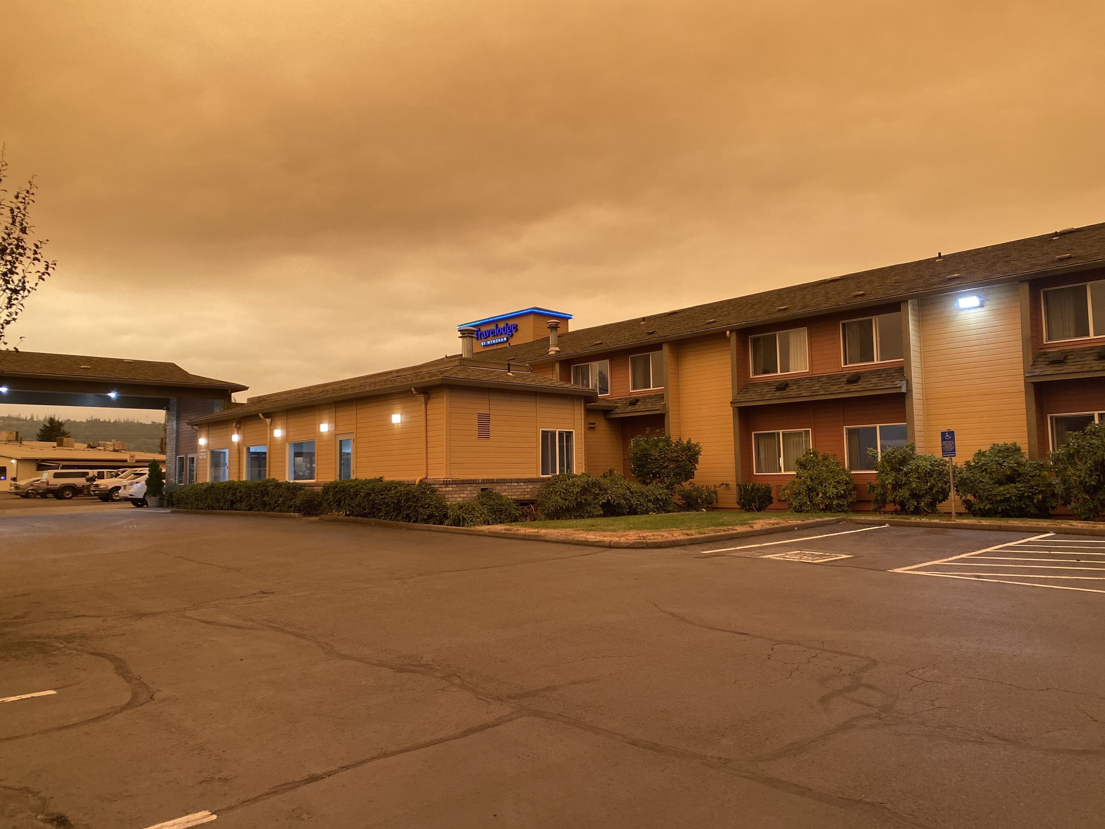 Un motel con aparcamiento y un edificio con un cartel que dice "Travelodge".