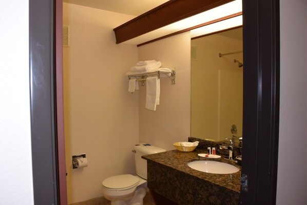 Un baño con inodoro, lavamanos y barra para toallas.