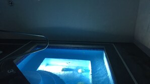 Un petit bain à remous rectangulaire, doté d’un revêtement intérieur en carrelage et d’une structure métallique.