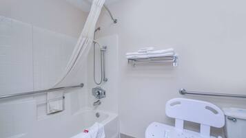 A bathroom with a bathtub, a shower, a toilet, and a wheelchair-accessible toilet.