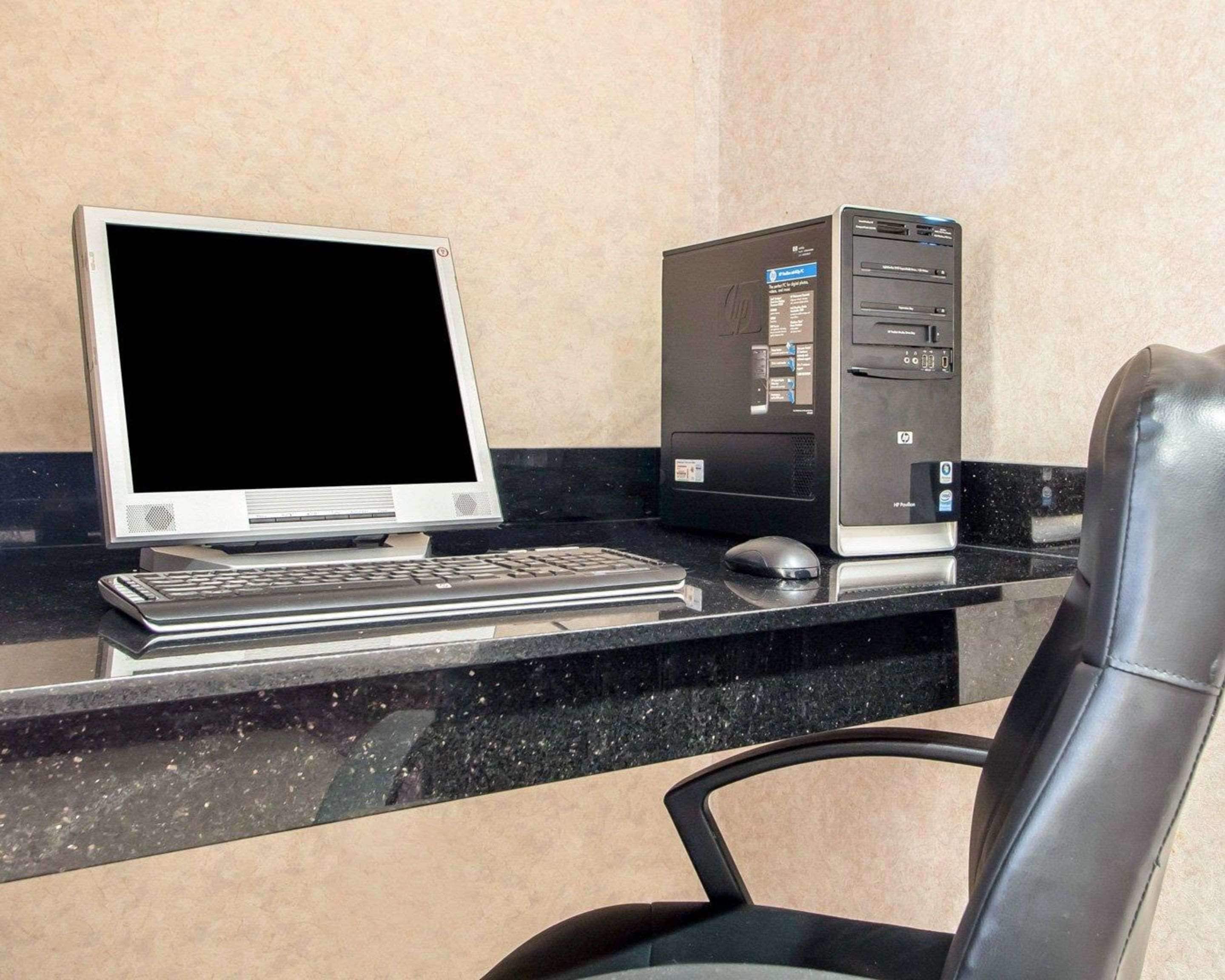 A computer desk with a desktop computer, monitor, keyboard, and mouse.