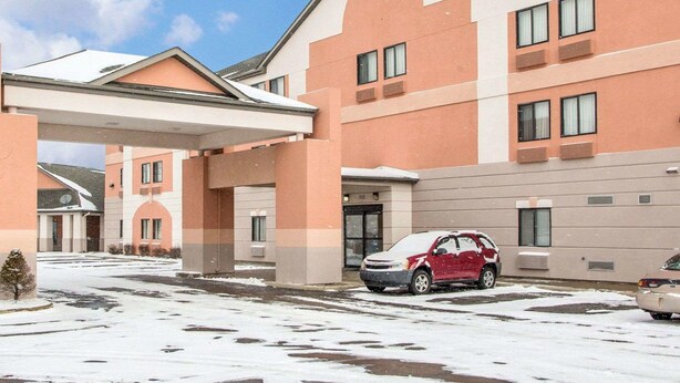 A multi-story hotel with a flat roof and a covered parking area.