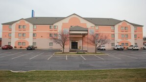 A multi-story hotel with a parking lot in front.