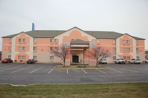 A multi-story hotel with a parking lot in front.