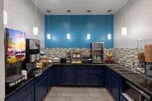 Una cocina con cafetera, refrigerador y dispensador de leche.