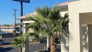 A Days Inn sign, palm trees, and a parking lot. - Days Inn by Wyndham El Paso West (El Paso)