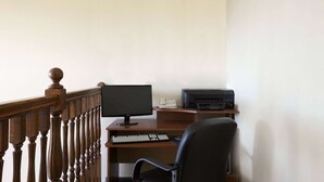 A wooden desk with a computer, keyboard, and printer. - Travelodge by Wyndham Grand Island (Grand Island)