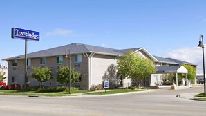 A Travelodge hotel with a clear sign, a covered entrance, and a parking lot. - Travelodge by Wyndham Grand Island (Grand Island)