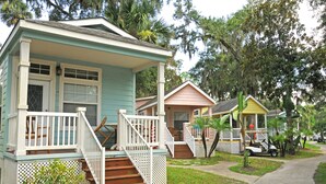 A row of small, single-story houses with front porches and steps leading to the door.