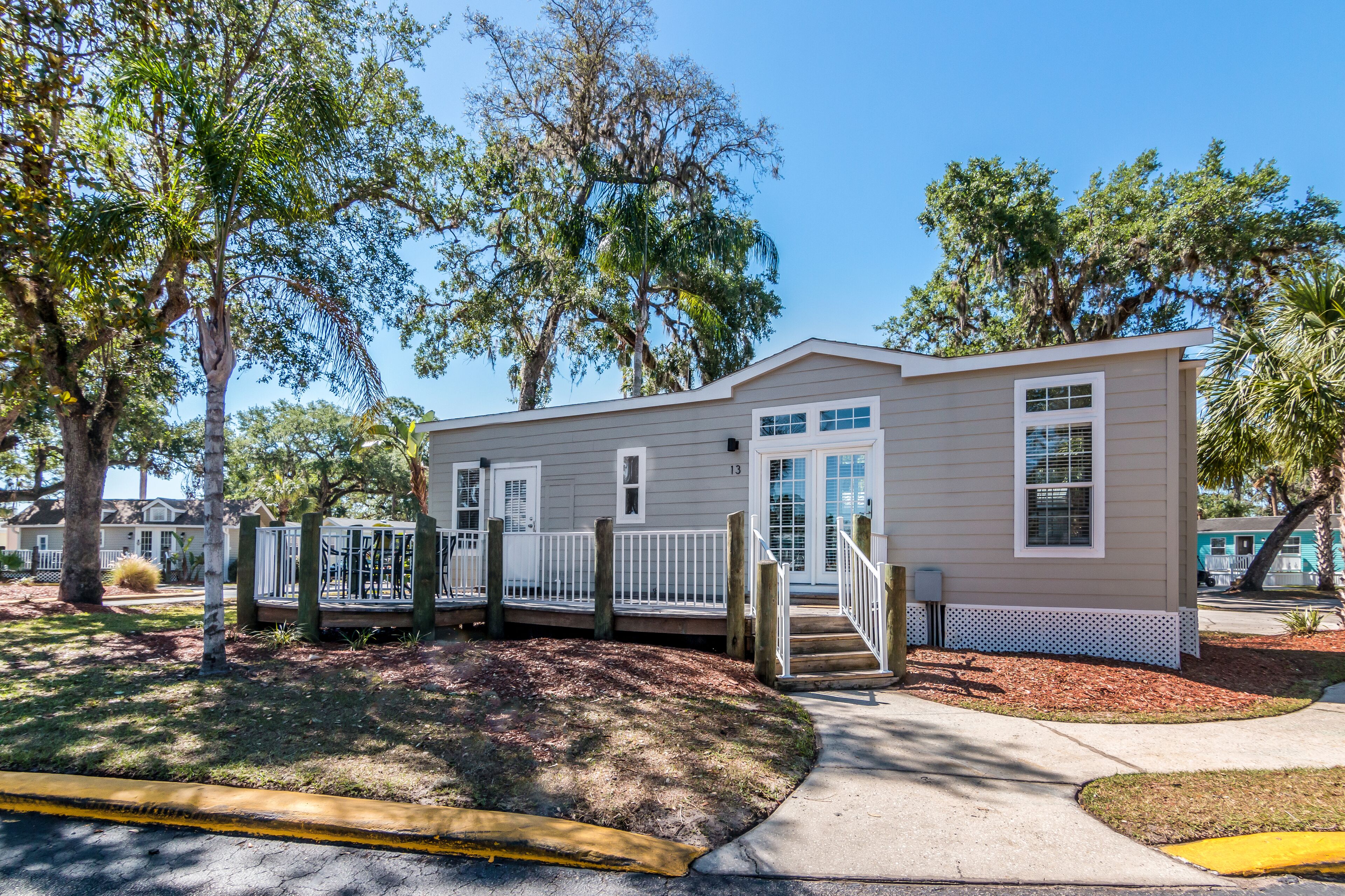 A single-story house with a front porch, a small deck, and a covered area.