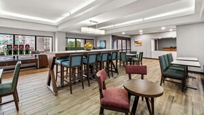 A modern hotel lobby with a bar area, seating arrangements, and large windows offering views of the city. - Hampton Inn Lexington/Georgetown (Georgetown)