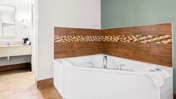 A modern bathroom with a freestanding bathtub, a tiled shower area, and a vanity with a mirror.