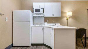 A compact kitchenette with a refrigerator, microwave, and sink. - Extended Stay America Suites Kansas City Overland Park Quivi (Overland Park)