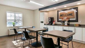 A modern hotel room with a large window, a 'WELCOME' sign, a coffee machine, and a small kitchenette. - Extended Stay America Suites Kansas City Overland Park Quivi (Overland Park)
