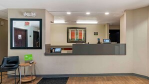 A reception area with a desk, a phone, a small table with a chair, and a sign indicating free Wi-Fi. - Extended Stay America Suites Kansas City Overland Park Quivi (Overland Park)