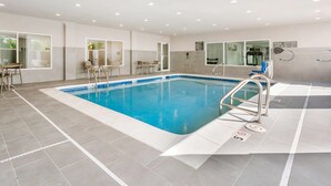Une piscine dotée d’une plage carrelée, d’un poste de surveillance pour les sauveteurs et d’un panneau indiquant la présence d’un dispositif d’élévation pour faciliter l’accès à la piscine.