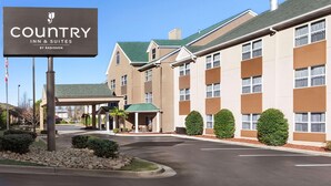 A Country Inn & Suites by Radisson building with a covered entrance, multiple windows, and a parking lot.