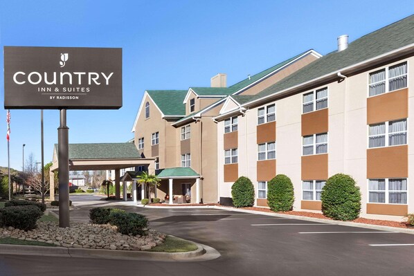 A Country Inn & Suites by Radisson building with a covered entrance, multiple windows, and a parking lot.