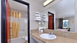 Une salle de bain équipée d’un lavabo, d’un miroir, d’un porte-serviettes et d’un rideau de douche.