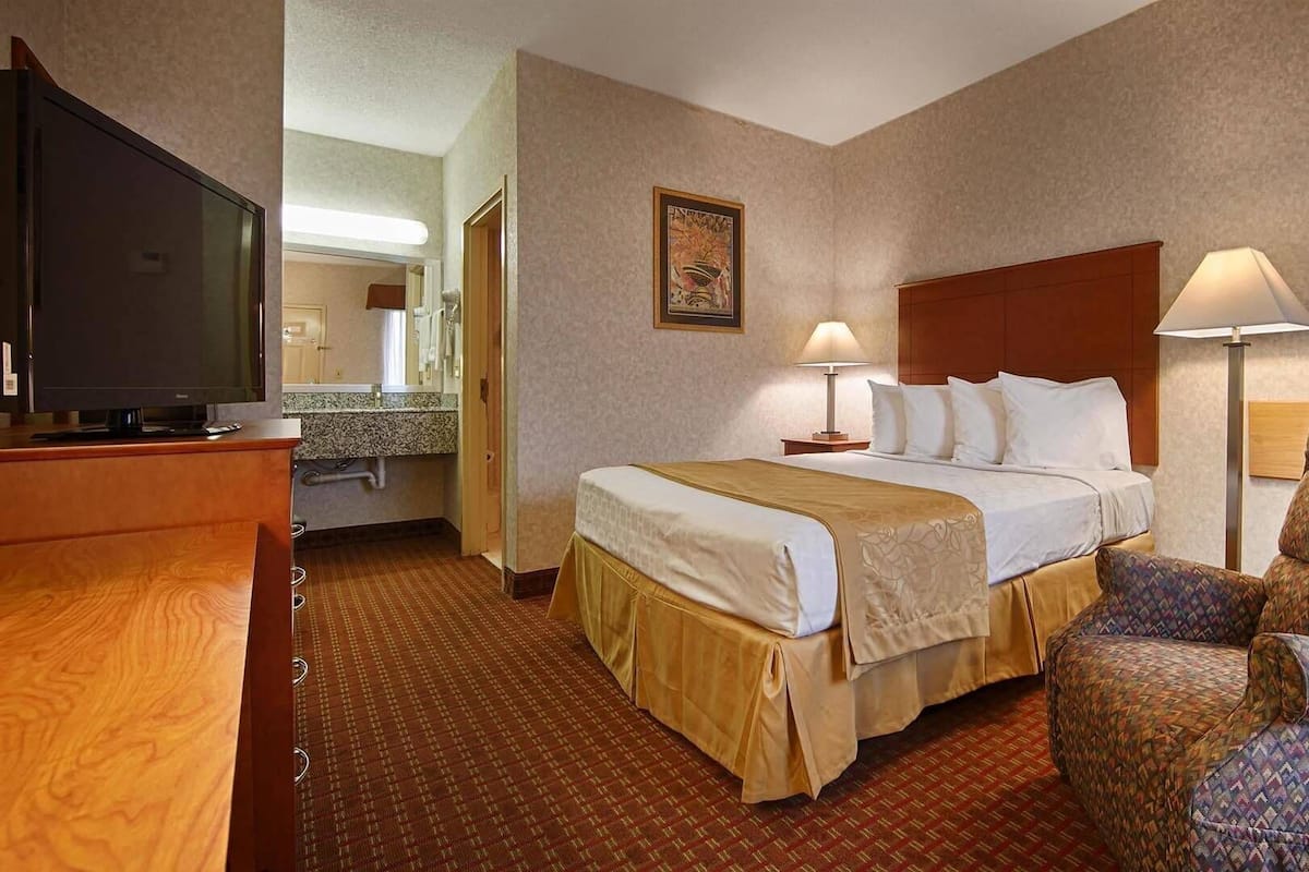 Une chambre d’hôtel équipée d’un lit, d’une télévision, d’un bureau, d’une chaise et d’une lampe.