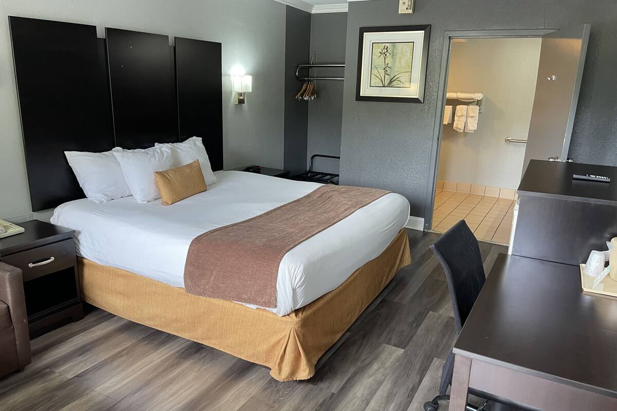Une chambre d’hôtel avec un grand lit, un bureau et une chaise.