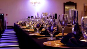 A long table set with multiple wine glasses, plates, and cutlery, likely in a banquet or event setting. - Radisson Hotel and Conference Center Rockford (Rockford)