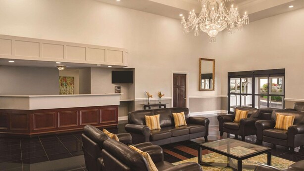 A spacious lobby with leather sofas, a chandelier, and a television. - Radisson Hotel and Conference Center Rockford (Rockford)