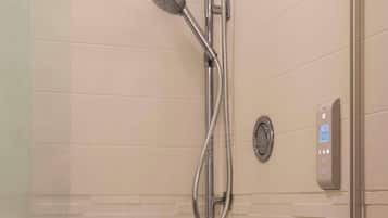 Une douche moderne dotée d’un panneau de commande numérique et d’un pommeau de douche à main.