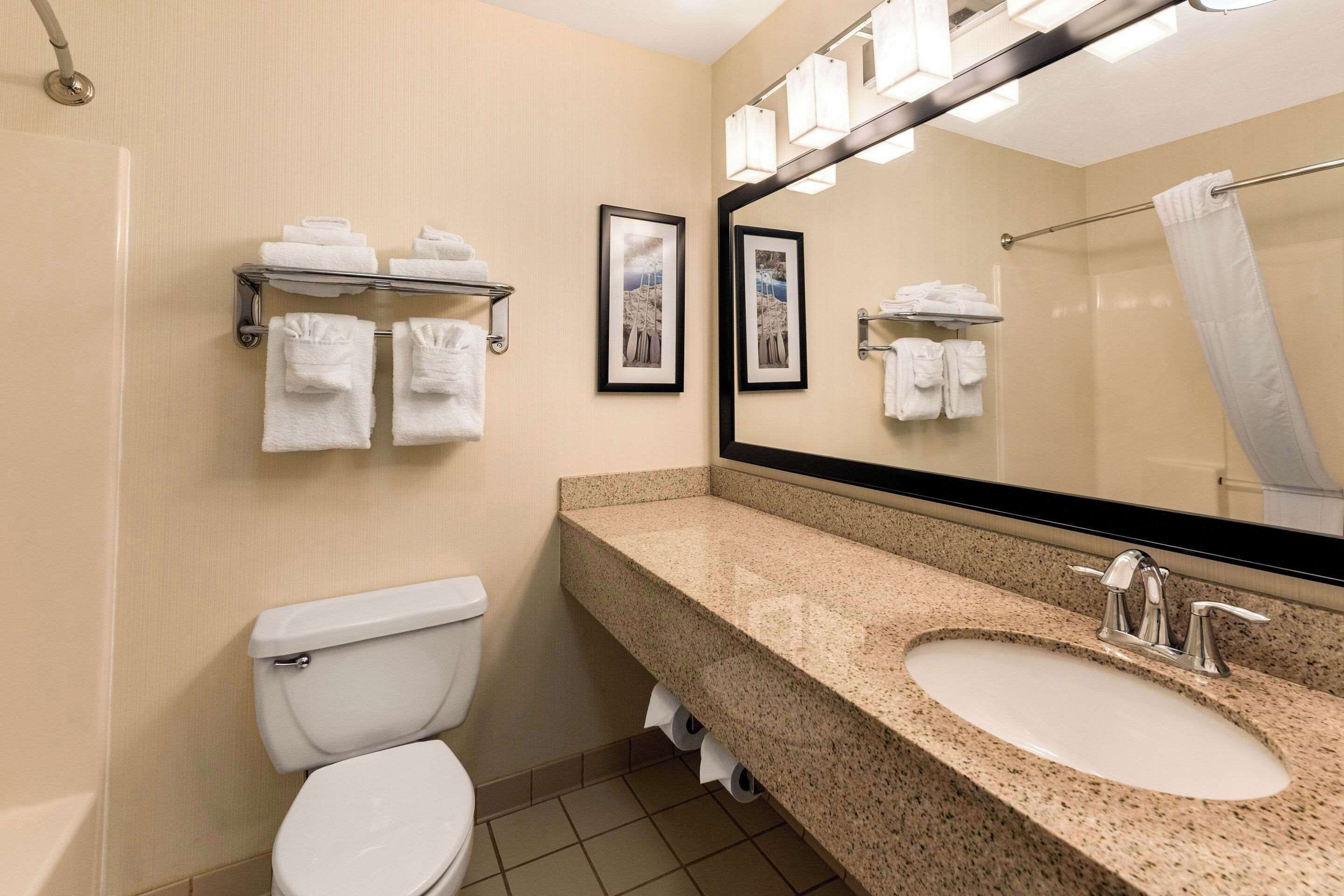 Une salle de bain équipée de toilettes, d’un lavabo et d’un porte-serviettes.