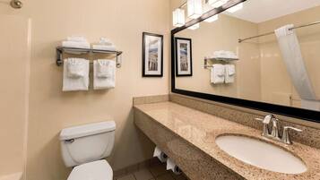 Une salle de bain équipée de toilettes, d’un lavabo et d’un porte-serviettes.