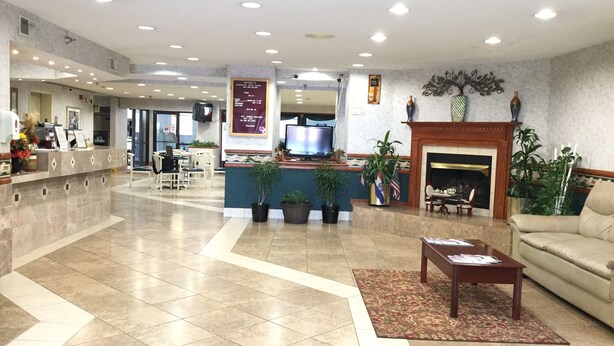 A spacious lobby with a reception desk, seating area, and a fireplace.