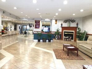 A spacious lobby with a reception desk, seating area, and a fireplace. - Americas Best Value Inn & Suites St. Louis, St. Charles Inn (St. Charles)