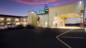 A hotel with a parking lot, a SureStay sign, and a BlueCross BlueShield sign.