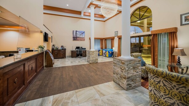 A spacious lobby with a reception desk, seating area, and a large arched window.
