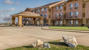 A multi-story hotel with a covered entrance and a landscaped lawn.
