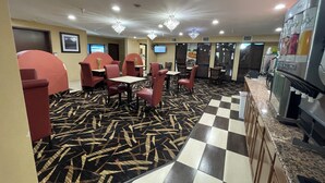 A hotel lobby with red seating, a checkered floor, and a large beverage dispenser.