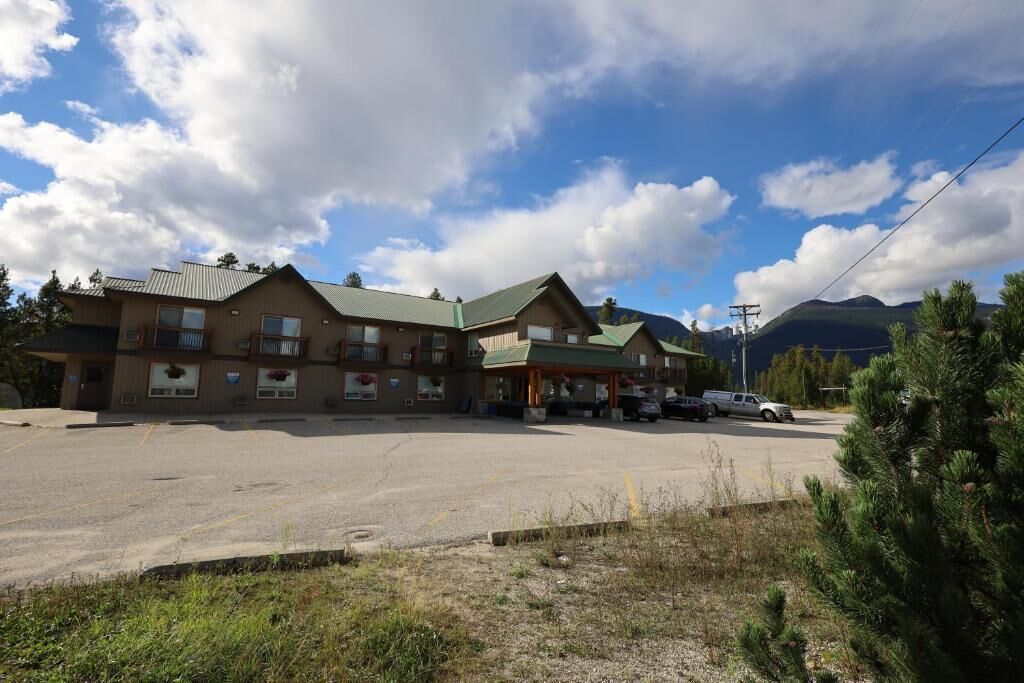 A two-story building with a parking lot in front.