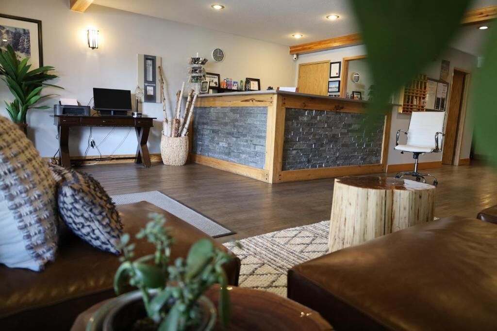A reception area with a wooden desk, a reception counter, and a seating area with a sofa and a coffee table.