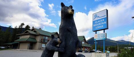Une statue d’ours avec une enseigne indiquant le « Glacier Mountain Lodge » et le « Grizzly Food Shack ».