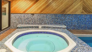 Un jacuzzi con revestimiento de azulejos y techo de madera.