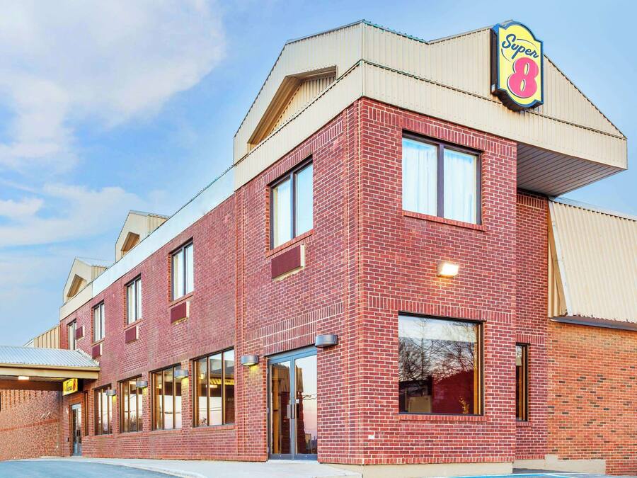 A red brick building with a large sign reading "Super 8" on the corner.
